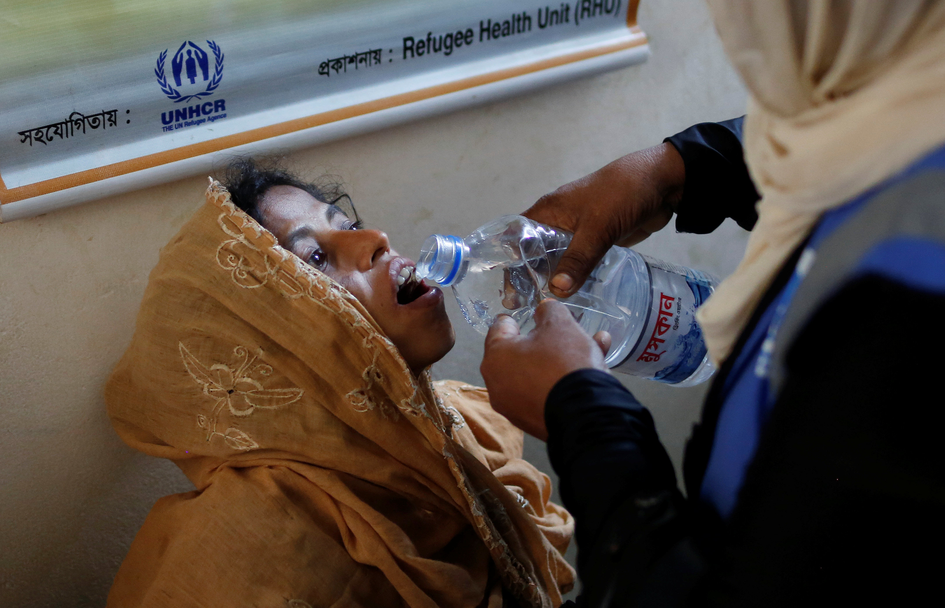 إحدى اللاجئات تشرب الماء