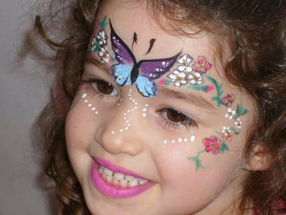 صورة عدة رسومات على وجه الطفلة مثل فراشة جميلة وزهور وألوان رائعة