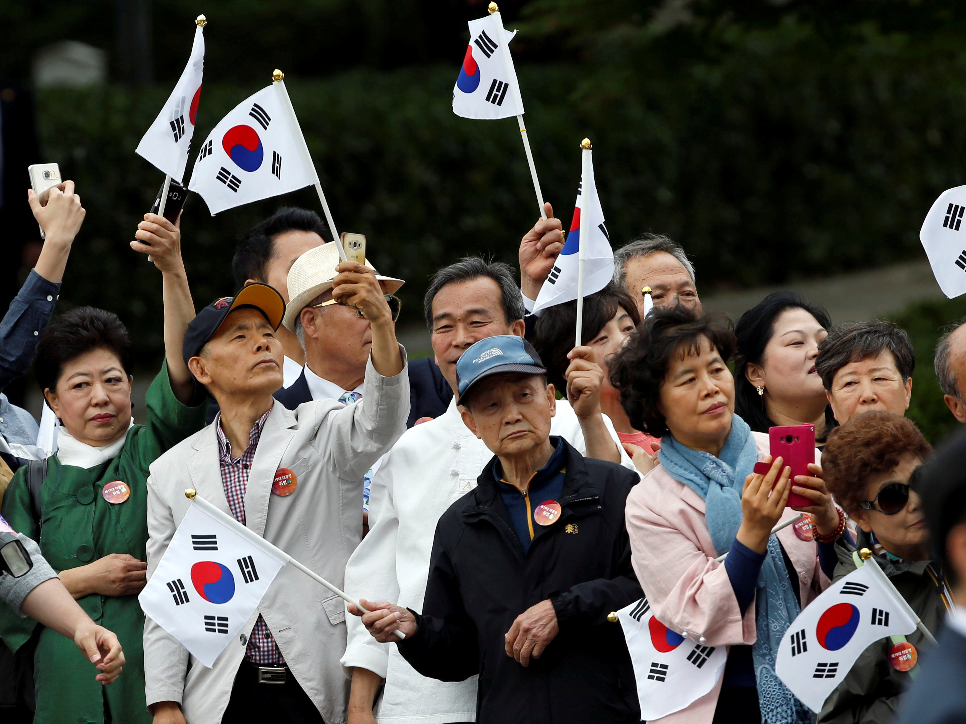 كوريون جنوبيون يرفعون علم بلادهم