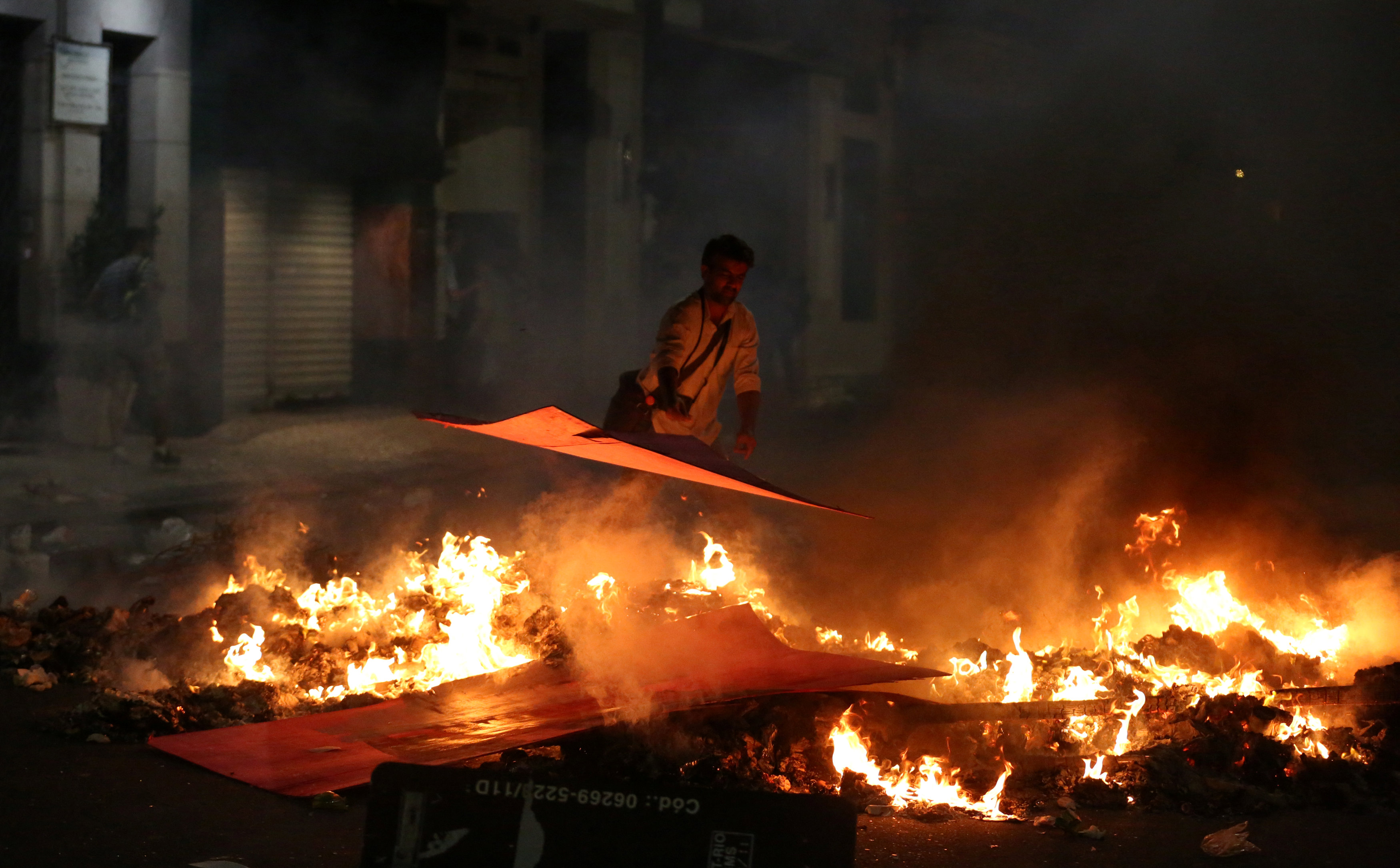 أحد المحتجين يشعل النيران احتجاجا على الرئيس البرازيلى المتهم بالفساد