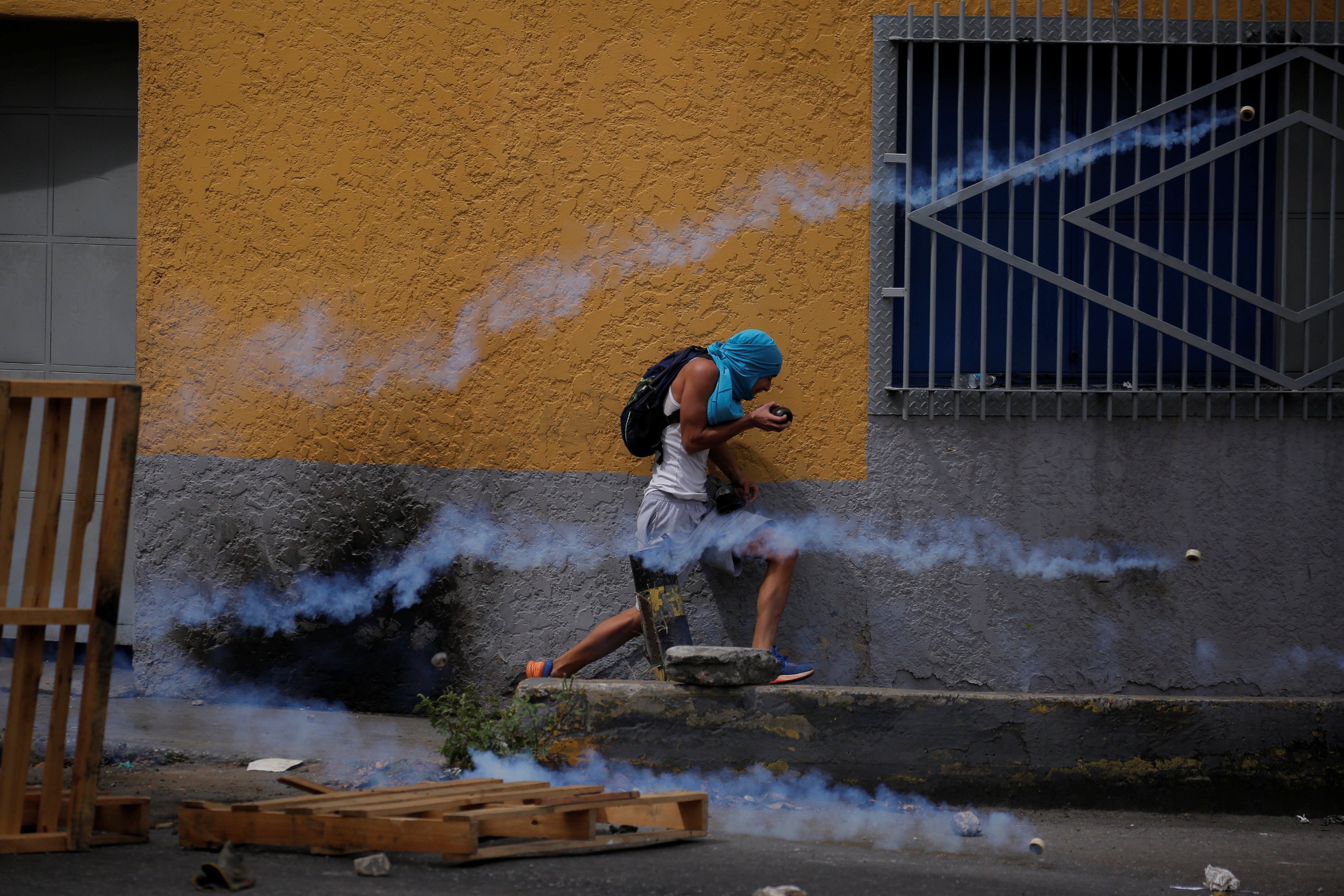 متظاهر يحاول الهروب من قنابل الغاز