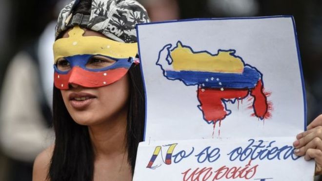 فتاة فنزويلية ترتدي قناع خلال مشاركتها بالاحتجاجات