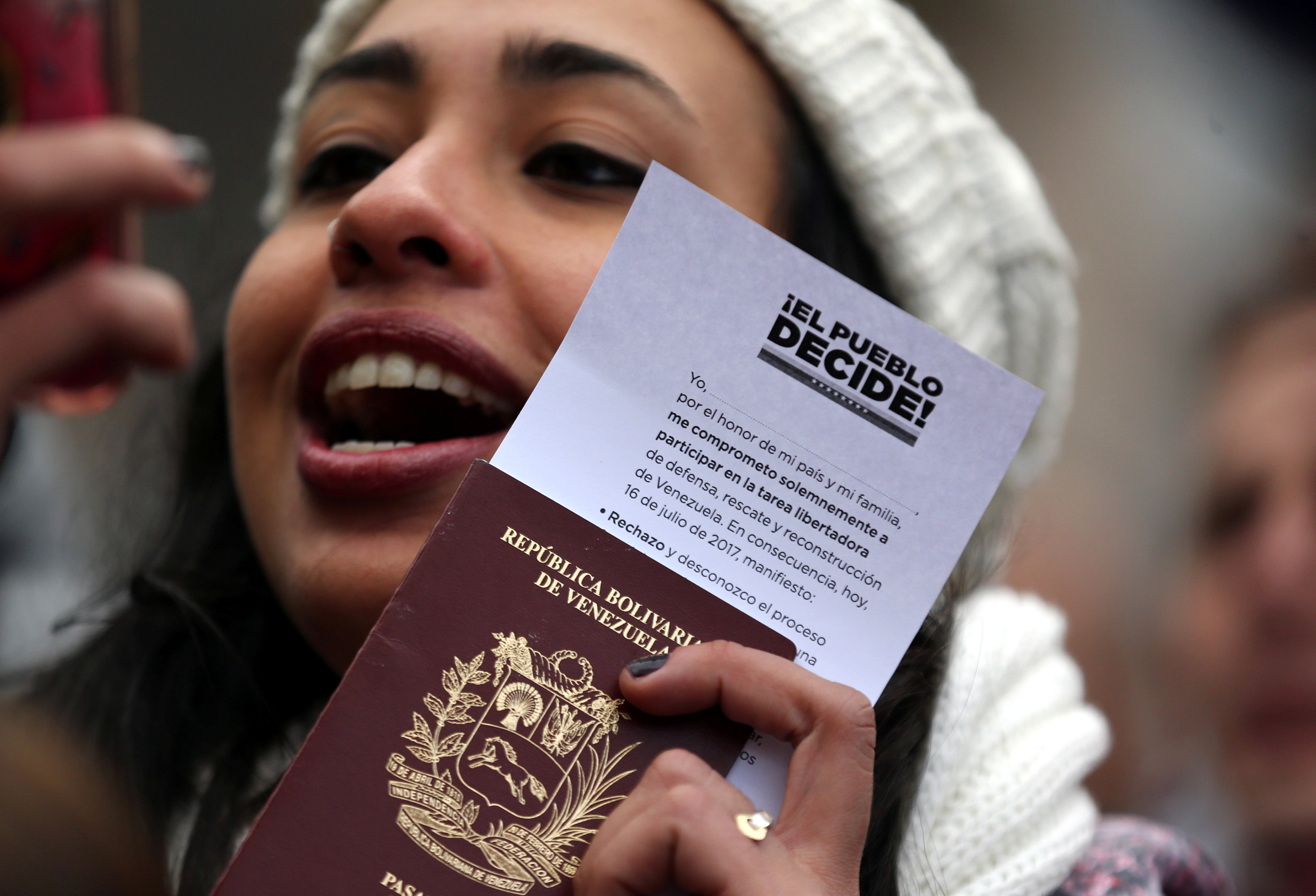 أحدى جميلات فنزويلا ترفع جواز السفر خلال الاستفتاء