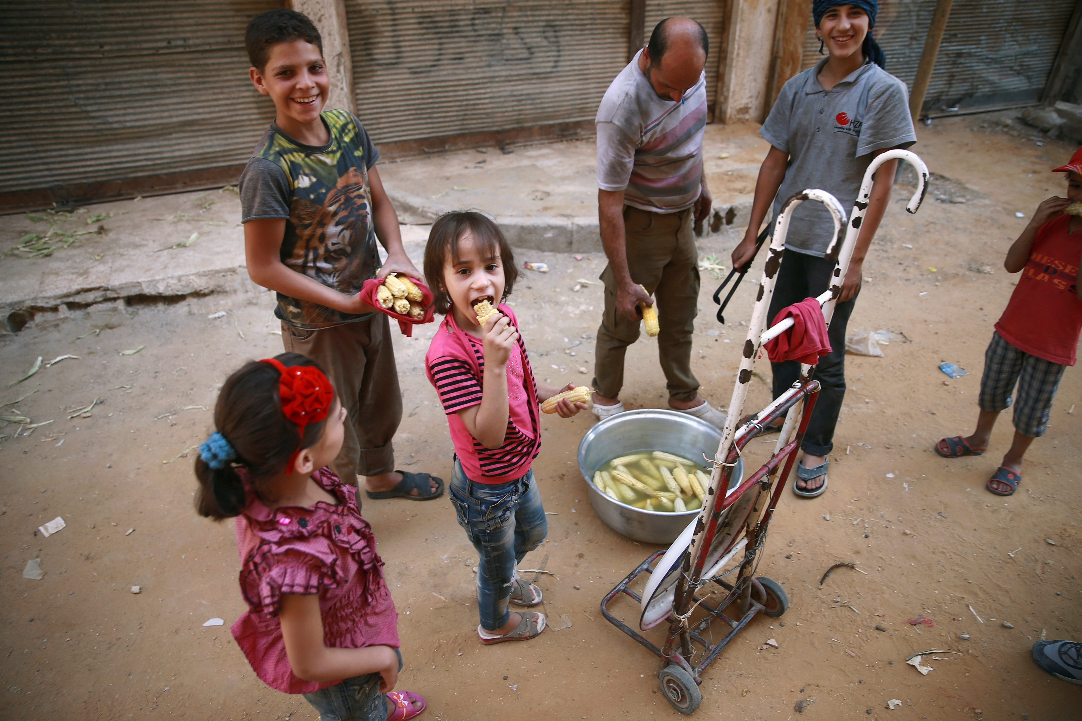 أطفال سوريون يأكلون الذرة