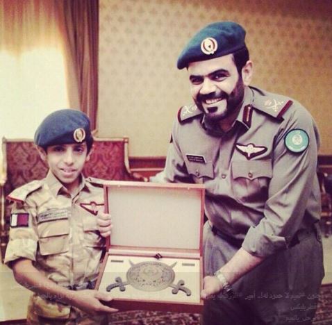 قائد عسكري قطري أثناء تقديم درع لنجل أمير قطر