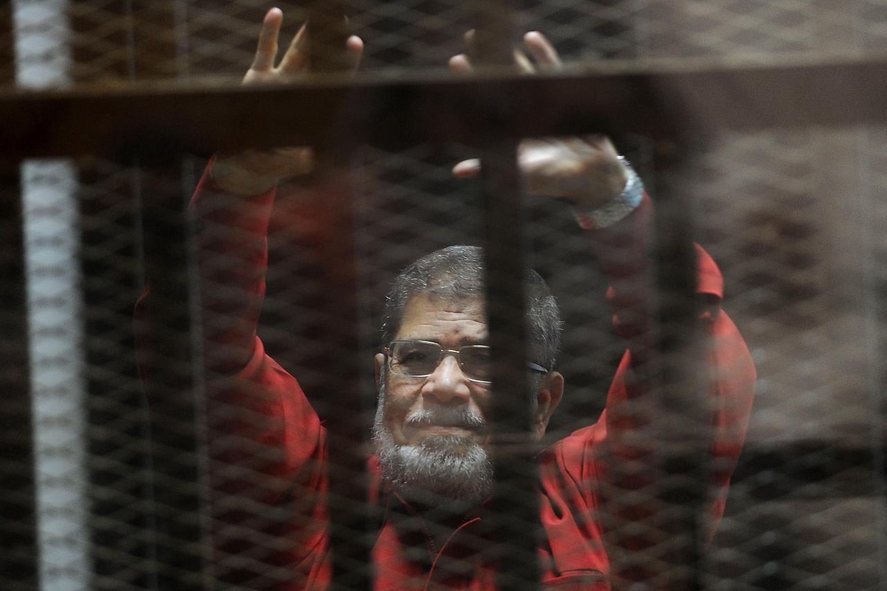مرسي المعزول في القفص بالبدلة الحمراء