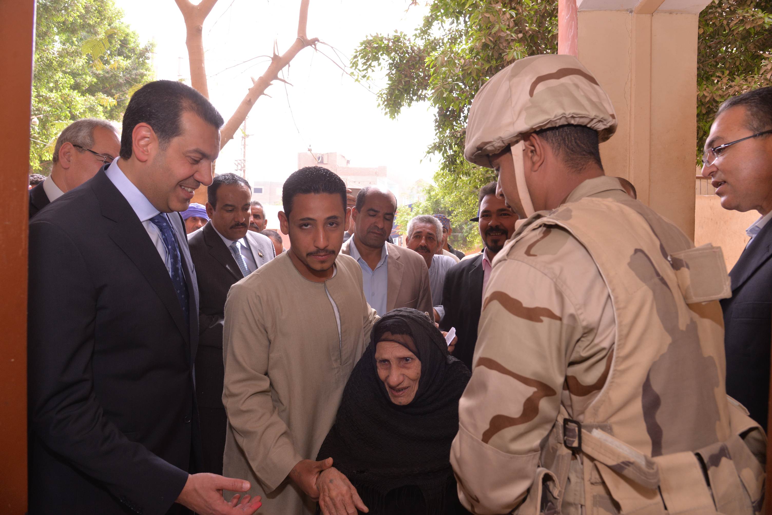 462095-حافظ-أسيوط-يصطحب-سيدة-مسنة-إلى-داخل-لجنة-(2)