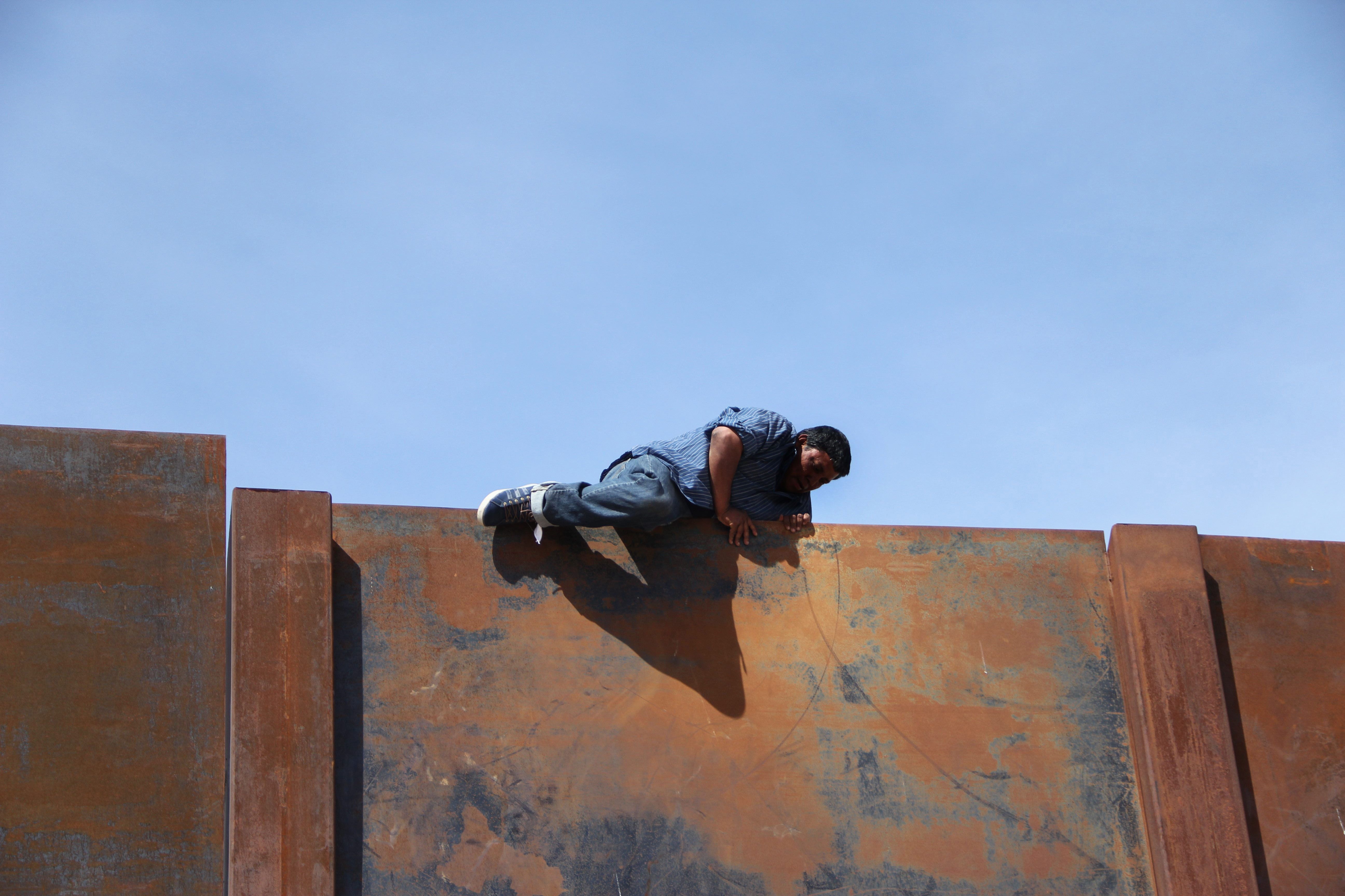 أحد المهاجرين فوق الجدار الحدودى