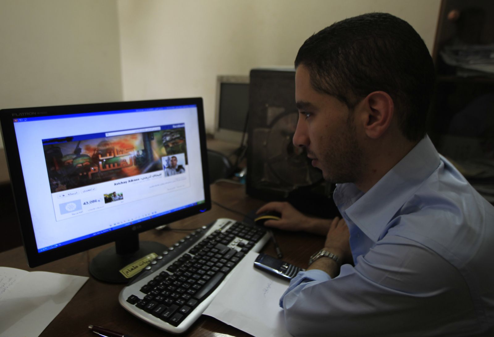 A-Palestinian-man-looks-at-the-Facebook-page-of-Avichay-Adraee-the-spokesman-of-the-Israeli-Army-to-the-Arabic-media
