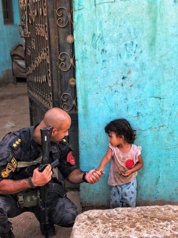 ضابط شرطة بالمنيا فى مشهد إنسانى مع طفلة