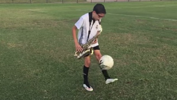 بالفيديو..طفل يمارس مهاراته فى عزف الساكسفون اثناء لعب الكرة   