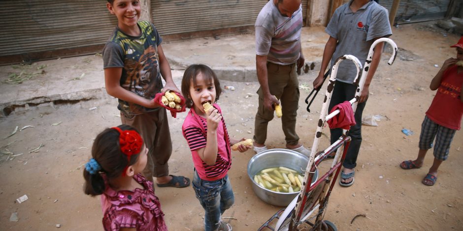 أطفال سوريون يتناولون الذره المشوى فى الغوطة الشرقية «صور»