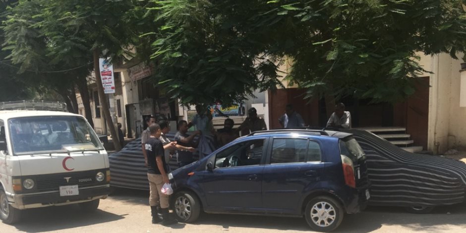 ضابط شرطة ينزل من سيارته ويساعد أحد المشردين في أسيوط (صور)