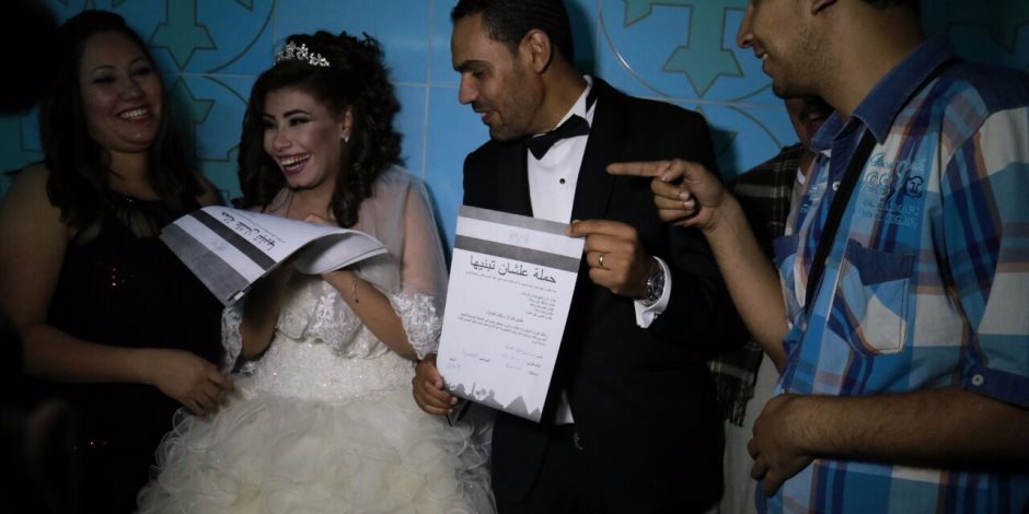 عروسان بأسيوط يوقعان استمارة "علشان تبنيها"