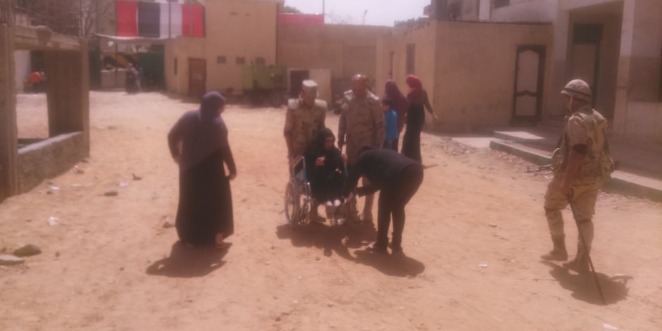 «اللي صان العرض».. قوات الجيش تحمل مسنة للجنتها الانتخابية بحلوان (صور)