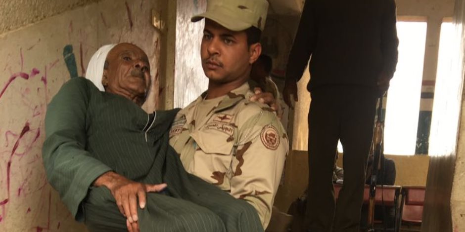 «جيل بيشيل جيل».. جندي قوات مسلحة يحمل مسن للإدلاء بصوته في المنيا