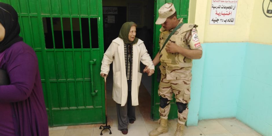 قوات الجيش تساعد مسنة للإدلاء بصوتها في الاستفتاء على التعديلات الدستورية (صور)