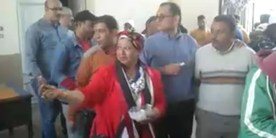 مواطنة ترتدي «علم مصر» وتوزع الحلوى أمام لجان الاستفتاء بالدقي (فيديو)