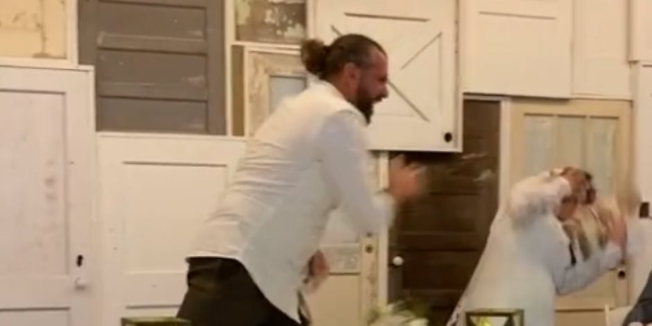 «هزار بوابين».. عريس يقذف عروسه بالتورتة أثناء حفل زفافهما (فيديو وصور)