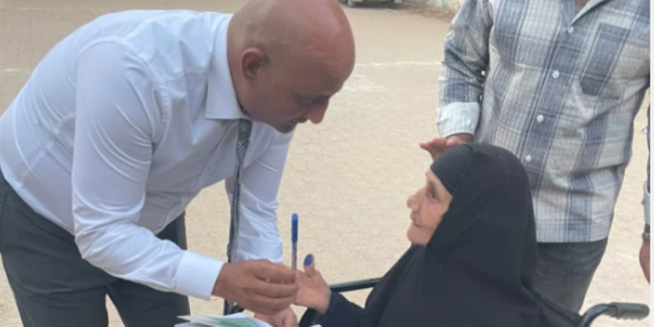 رئيس لجنة بالفيوم يتوجه إلى مسنة خارج اللجنة لمساعدتها على الإدلاء بصوتها رئيس لجنة بالفيوم يتوجه إلى مسنة خارج اللجنة لمساعدتها على الإدلاء بصوتها
