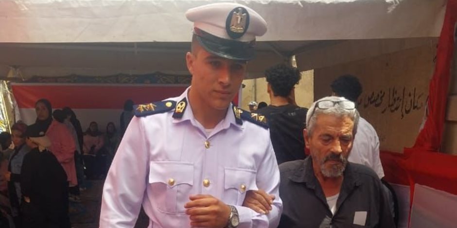 رجل شرطة يساعد مسنا للوصول إلى لجنته الانتخابية فى حدائق القبة رجل شرطة يساعد مسنا للوصول إلى لجنته الانتخابية فى حدائق القبة