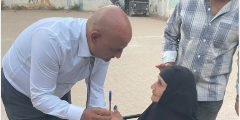 رئيس لجنة بالفيوم يتوجه إلى مسنة خارج اللجنة لمساعدتها على الإدلاء بصوتها رئيس لجنة بالفيوم يتوجه إلى مسنة خارج اللجنة لمساعدتها على الإدلاء بصوتها