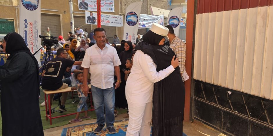 سيدة تحضنن الشرطه النسائيه بعد الاقتراع بصوتها فى أحد لجان اسوان 