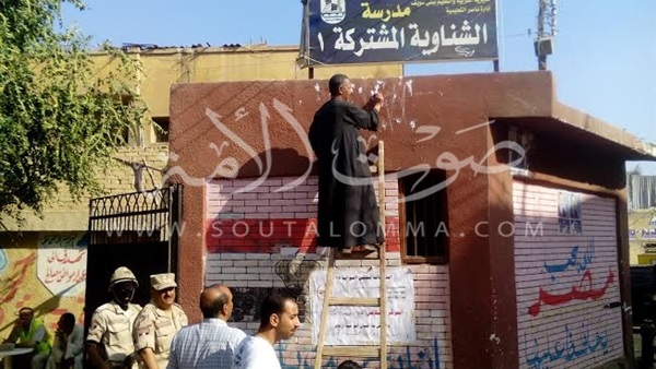 بالصور.. إزالة الدعاية الانتخابية من على جدران اللجان ببني سويف