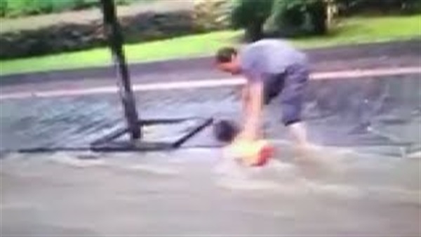 بالفيديو.. رجل صيني ينقذ طفل جرفته مياه الفيضان