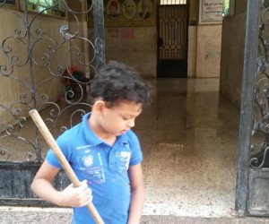 "بالمساحة والخرطوم".. طالب يشارك في تنظيف مدرسته بالعمرانية (صور) 