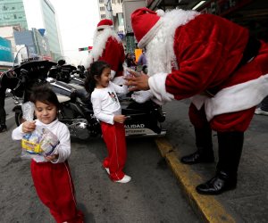 شرطة المكسيك ترتدي ملابس بابا نويل وتوزع الحلوي على الأطفال (صور) 