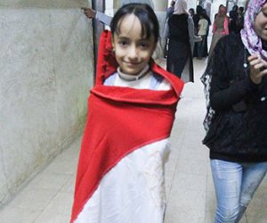 طفلة تتشح بعلم مصر أمام اللجنة الانتخابية بالعياط