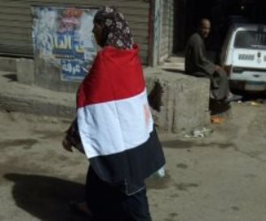 عجوز ترتدى علم مصر وتجوب شوارع فيصل لحث المواطنين على المشاركة بالانتخابات
