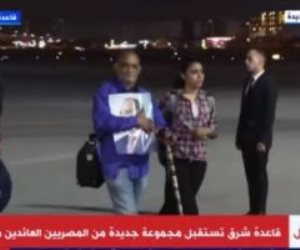 مواطن عائد من السودان يحمل صورة الرئيس السيسي لدى وصوله مطار قاعدة شرق