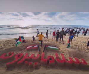 جريح فلسطينى يتضامن مع اللبنانيين فى ظل العدوان بنحت لوحة على شواطئ غزة