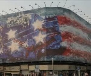 من يزرع الريح يحصد عاصفة.. إيران تحذر ترامب بعلم ملطخ بالدماء على لوحة إعلانية ضخمة في طهران