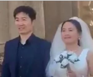 سائح صيني يحتفل مع زوجته بفستان وبدلة الزفاف في معبد الأقصر .. صور