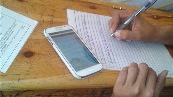 مراقب يلقى بورقة أسئلة لأحد اولياء امور الشهادة الإعداداية بكفر الشيح