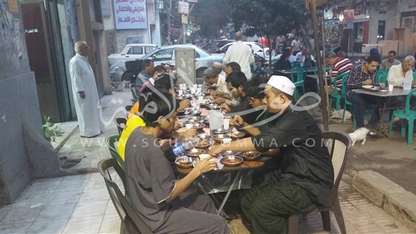 بالصور.. لحظة إفطار الباعة الجائلين بالدقي