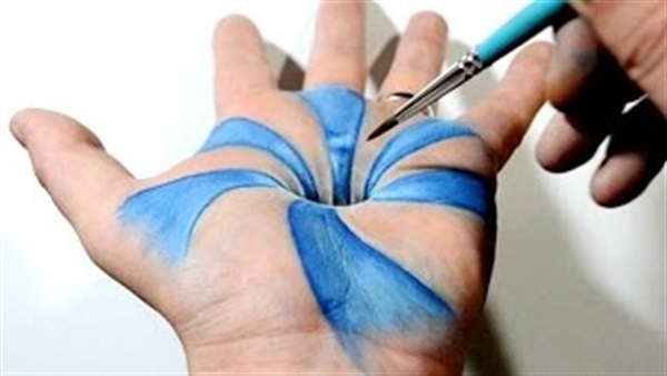 رجل يرسم على يده بتقنية 3D