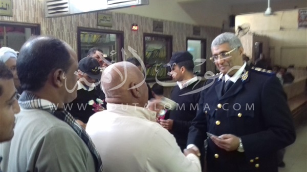 ضباط يوزعون الزهور والحلوى على المتقدمين لاستخراج الرخص بالأقصر